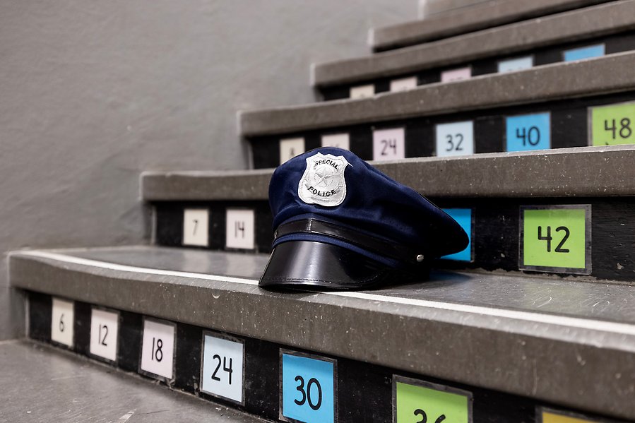 Närbild på trappsteg. På trappstegen är flera lappar med olika färger fasttejpade. På ett av trappstegen ligger en polishatt. 